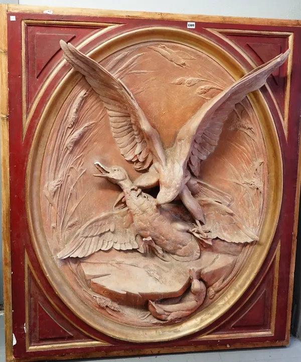 A large oval relief moulded plaque, signed 'CAIN', depicting a bird of prey attacking a duck, in a red and gilt painted frame, 148 x 126cm.