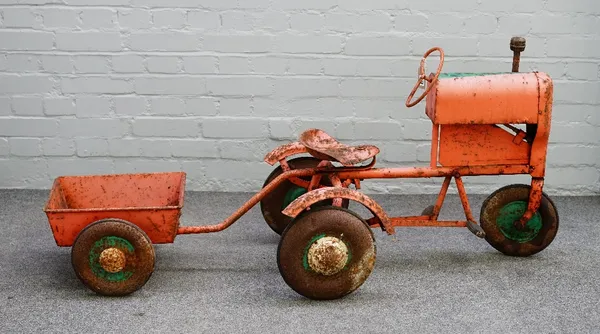 A mid-20th century Triang tin plate pedal tractor and cart, 71cm high with a combined length of 165cm.