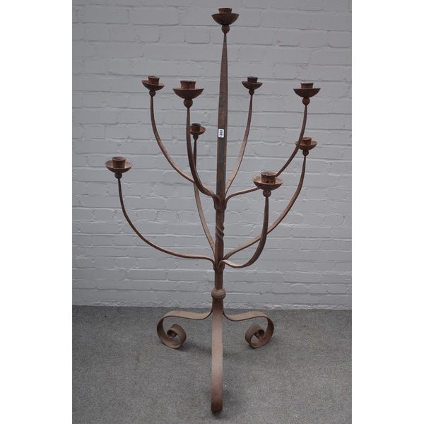 A large modern wrought iron nine branch floor standing candelabra, on three scroll supports, 164cm high x 74cm wide.