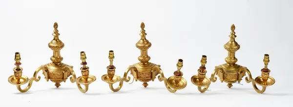 A set of six 20th century gilt metal twin branch wall lights, with flame finials, fitted for electricity, 28cm high, (6).