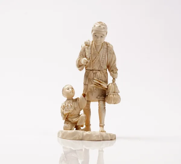 A Japanese sectional ivory okimono, Meiji period, carved with a man standing with a bundle of leaves, a boy kneeling at his side, signed, 17cm high, w