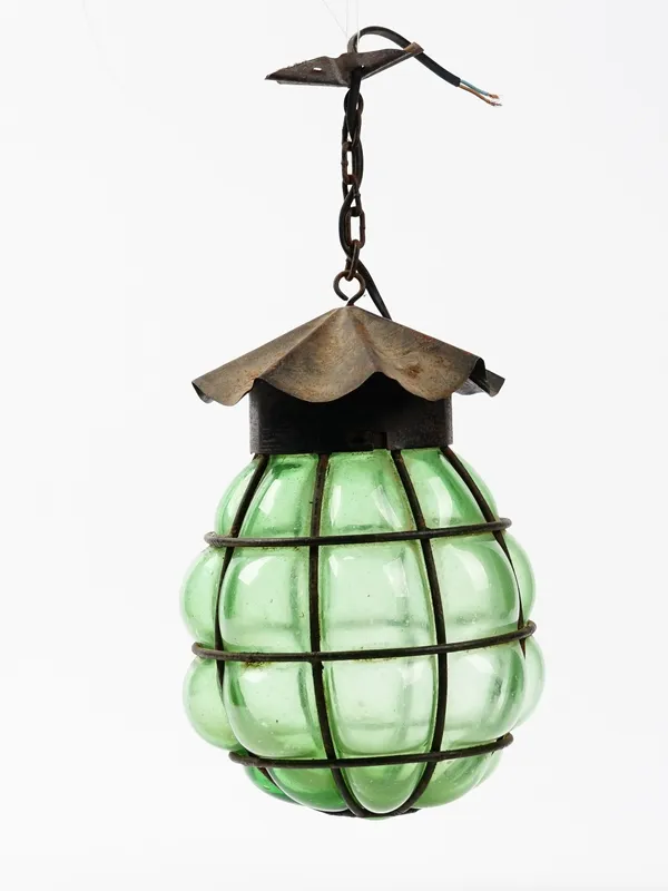 An Arts and Crafts green glass and metal caged lantern, suspended from a chain, 38cm high.