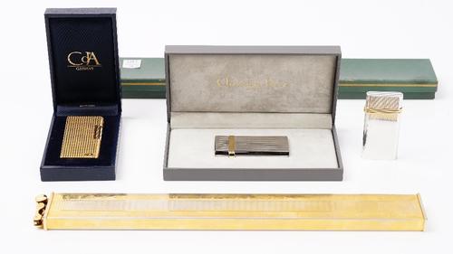 A Christian Dior bicolour steel and gold plated gas lighter, boxed, and another without box, a Caran d'ache gold plated gas lighter, boxed, and a larg