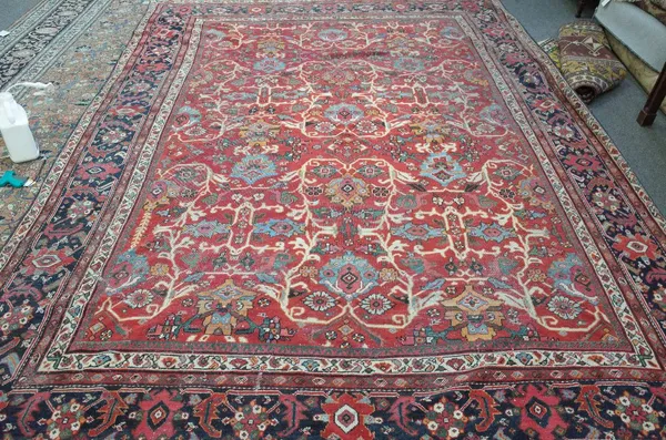 A Mahal carpet, Persian, the madder field with an allover palmette and floral vine design, an indigo palmette and rose border, 388cm x 290cm. 6920