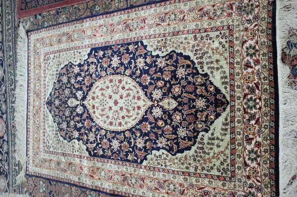 A Hereke silk and metal thread rug, Turkish, the dark indigo field with a pale sage medallion and spandrells, all with delicate floral sprays, a metal