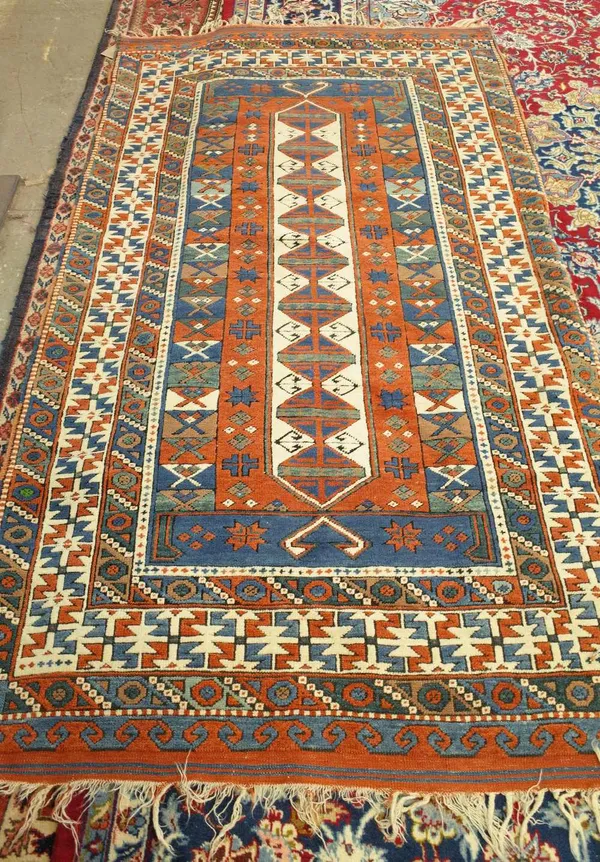 A Turkish rug, the indigo field with an ivory and madder lozenge medallion bearing nine diamonds; an ivory stylised flowerhead border, 225cm x 125cm.