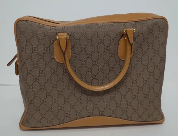 A Gucci GG lady's canvas and tan leather soft briefcase, with two leather top carrying handles and gold-tone hardware the top zip opening to reveal a