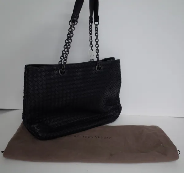 A Bottega Veneta black woven leather tote bag, with two chain and black leather straps, to a three compartment and zipped leather and suede lined inte