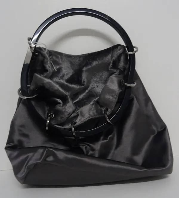 A Gucci lady's silver satin evening bag, of hoop drawstring design, with front zipped pocket and grey/silver lined interior