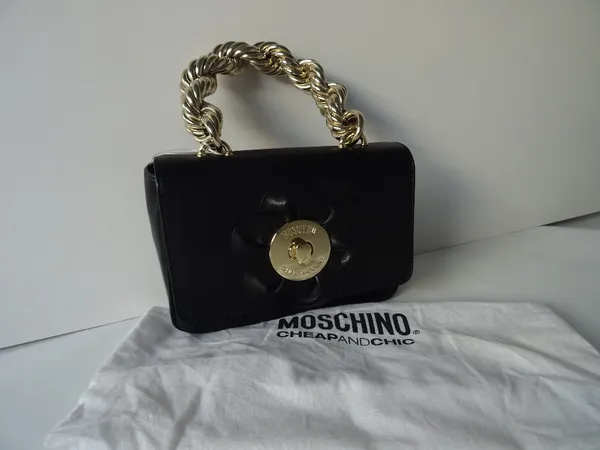 A Moschino Cheap and Chic black leather evening bag with a gold-tone hardware rope twist handle, and flowerhead motif to the front flap, with leather