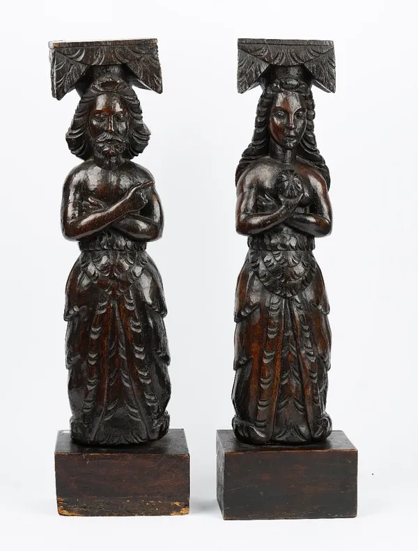 A pair of 19th century carved oak finials, depicting a man and a woman in standing pose, each 73cm high.