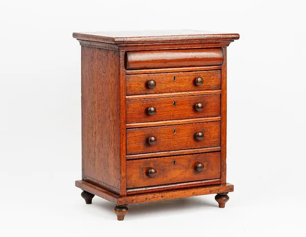 A miniature mahogany chest with a cushion drawer over four long graduated drawers on bun feet, 32cm wide x  41cm high.