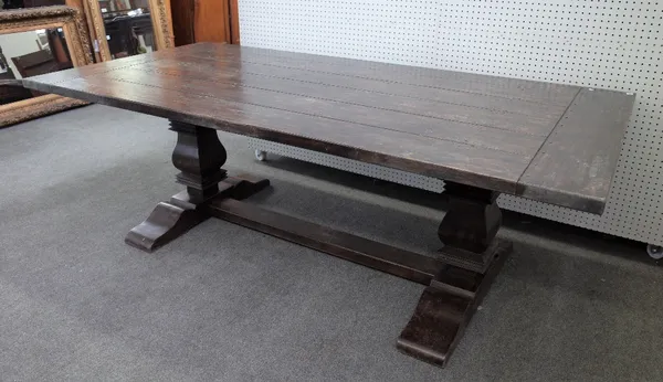 A 17th century style oak refectory table, the cleated plank top with pegged biscuit joints on square baluster supports united by a stretcher, 112cm wi