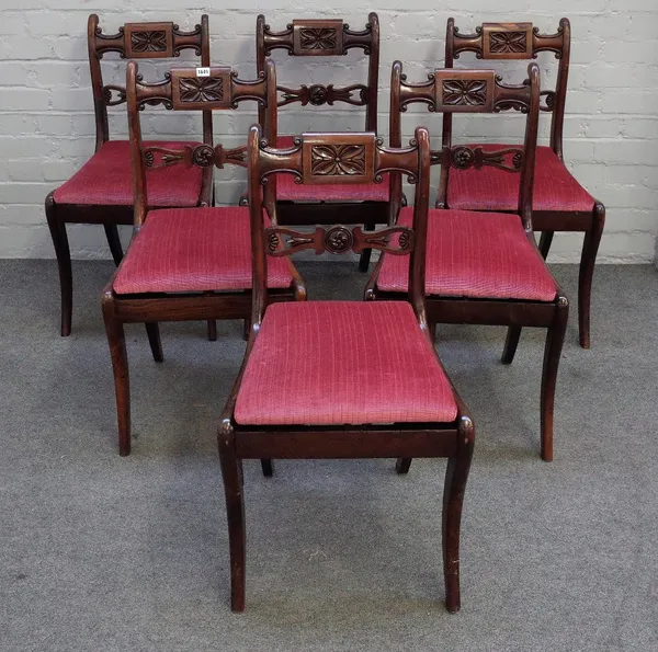 A set of six late Regency yew wood dining chairs, with flowerhead carved tablet centred top rails flanked by 'C' scrolls, lotus carved and pierced bar