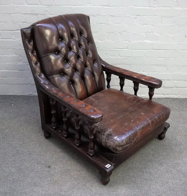 A mahogany open arm easy chair, with button back brown leather upholstery, on turned supports, 75cm wide x 89cm high.