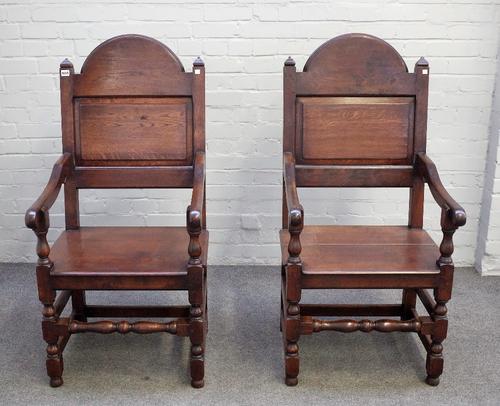 A pair of 17th century style oak panel back open armchairs on turned supports, 59cm wide x 120cm high (2).