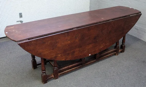 A large reproduction Charles II style oak gateleg table, the hinged oval top on baluster turned and square section legs, 155cm wide x 230cm long x 76c