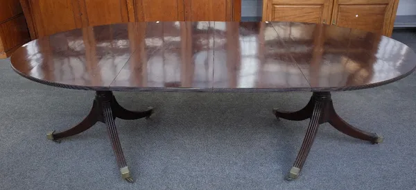 A George III mahogany oval extending dining table, on pair of turned columns and six downswept supports, with two extra leaves, 122cm wide x 143cm lon