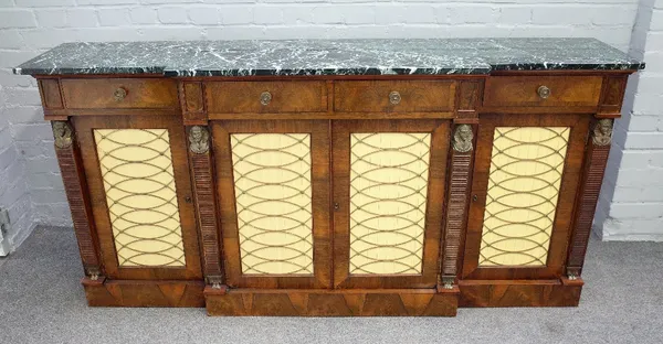 A Regency style breakfront sideboard, the marble top over a rosewood base with four drawers and four brass lattice work cupboards, divided by Egyptian