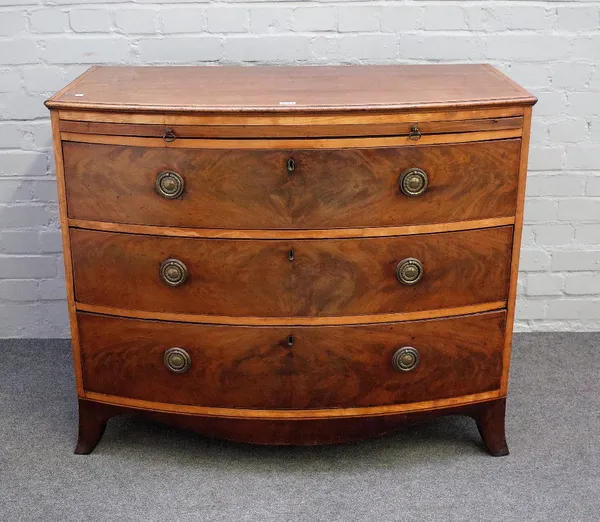 A Regency satinwood banded mahogany bowfront chest with brushing slide over three long graduated drawers on splayed supports, 102cm wide x 85cm high.