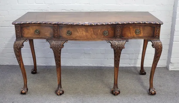 An 18th century style mahogany serving table, the gadrooned serpentine top over three frieze drawers, resting on six claw and ball supports, 125cm wid