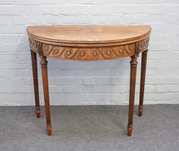 A late 19th century mahogany semi elliptic card table with carved frieze on tapering fluted supports, 92cm wide x 76cm high.