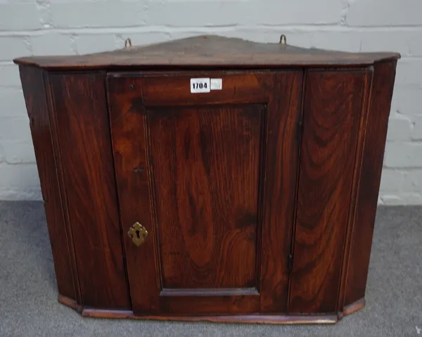 An 18th century elm hanging corner cupboard with a single panel door, 67cm wide x 53cm high.