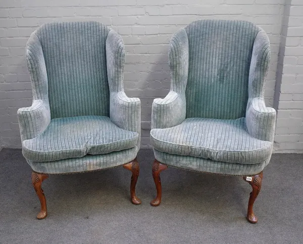 A pair of George I style striped blue upholstered wingback armchairs, on shell capped walnut supports and pad feet, 81cm wide x 120cm high.