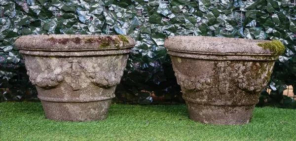 A pair of reconstituted stone circular jardinieres with floral swag decoration, 49cm diameter x 34cm high.