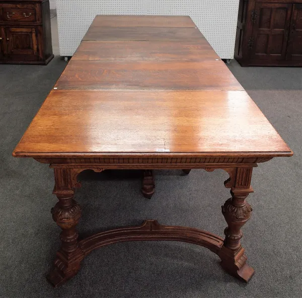 A 19th century German oak extending dining table on carved baluster supports united by shaped stretcher, 112cm wide x 138cm long, 440cm long fully ext