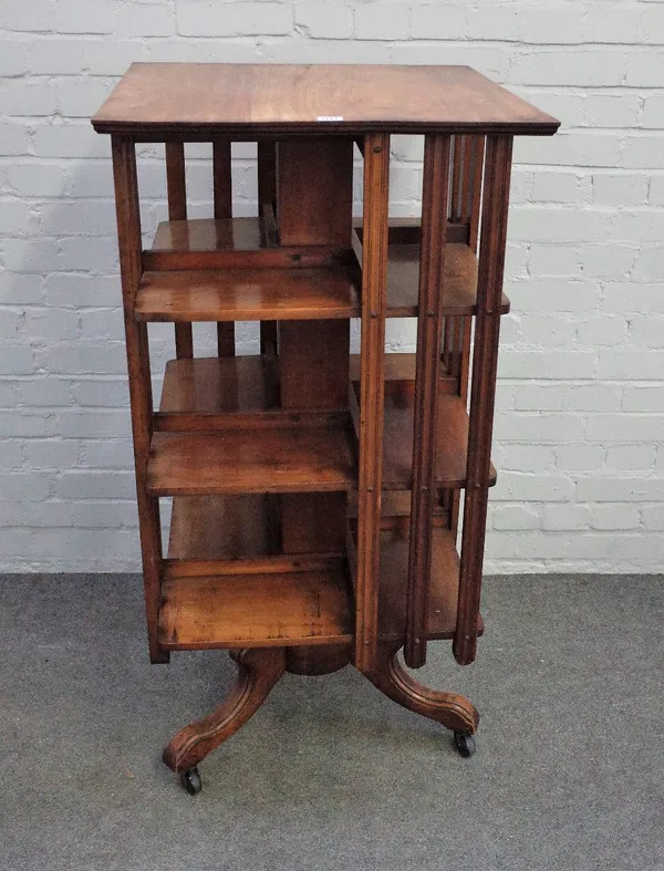 An Arts & Crafts walnut square four tier revolving bookcase, on three downswept supports, 60cm wide x 119cm high.