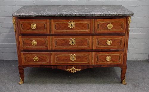A Louis XV style gilt metal mounted parquetry inlaid kingwood commode, the marble top over three short and two long drawers on squat scroll supports,