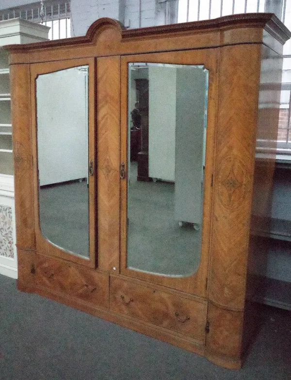 A late 19th/early 20th century satinwood wardrobe with a pair of bevelled glazed doors over a two drawer base, 220cm wide x 223cm high.