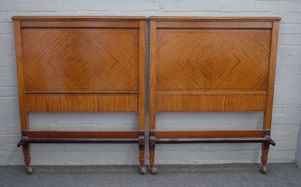 A pair of late 19th century, early 20th century satinwood single beds with concave footboards, 92cm wide x 119cm high (2).