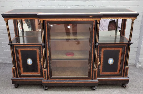 A Napoleon III ebonised amboyna crossbanded boxwood strung gilt metal mounted credenza, of breakfront outline, enclosed by a central glazed door, flan