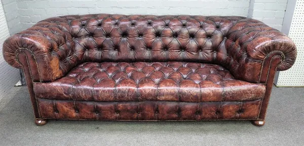 A 20th century button back brown leather upholstered Chesterfield, with brass studded decoration, on bun feet, 225cm wide x 79cm high.