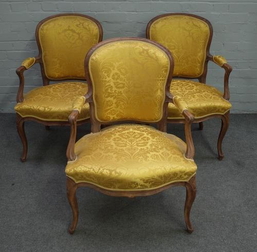 A set of three 18th century style French stained beech open armchairs with serpentine seat on cabriole supports, 65cm wide x 92cm high.