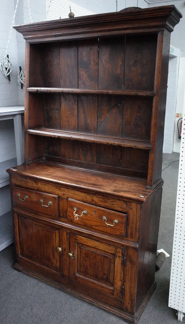 An elm dresser, 18th century, with two drawers and a cupboard below, with raised and fielded panel doors, the associated boarded rack of later date, 1