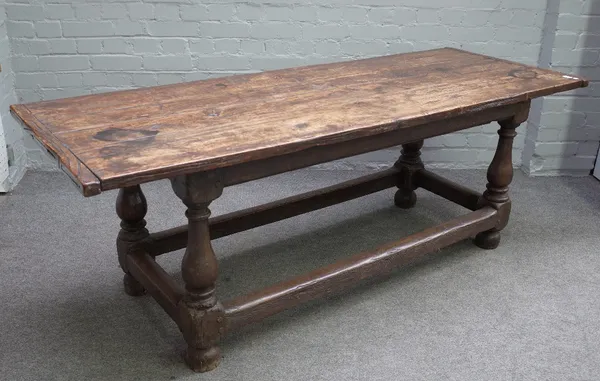 A 17th century and later oak refectory table, the cleated top on baluster turned supports, united by stretcher, 69cm wide x 188cm long.