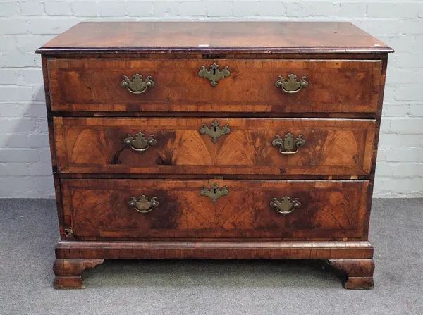 A George II featherbanded walnut chest with four long graduated drawers, on ogee bracket feet, 115cm wide x 91cm high.