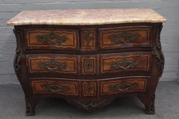 An 18th century Baltic commode, the serpentine marble top over a gilt metal mounted rosewood and kingwood bombé base with two short and two long drawe