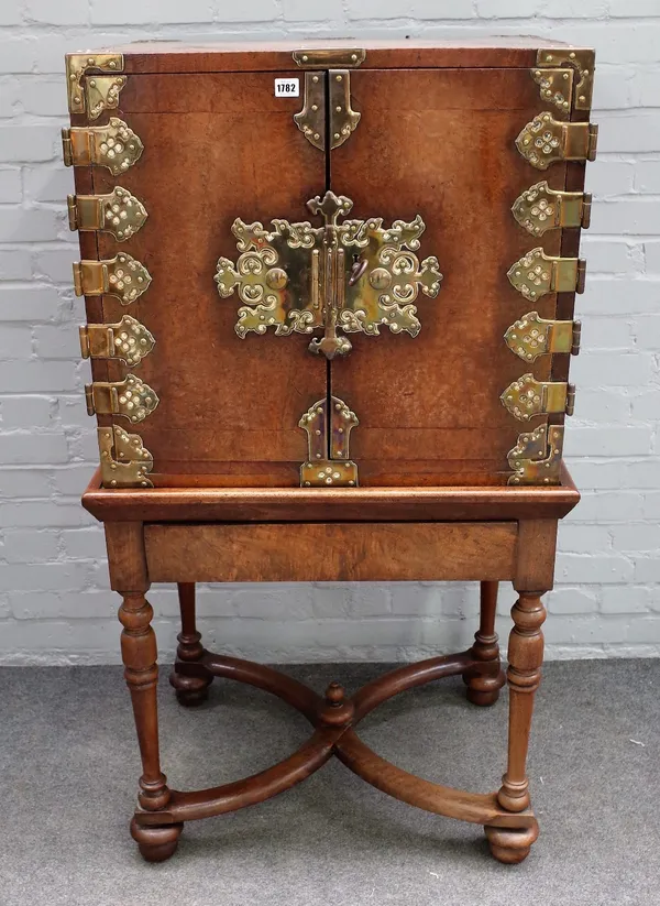 An 18th century Portuguese East Indies solid burr walnut and brass mounted cabinet, enclosed by a pair of doors with ornate cut and pierced hinge moun