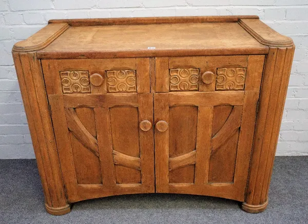 An Arts & Crafts design stripped oak sideboard with pair of 'tree of life' carved drawers over moulded cupboards flanked by outstepped reeded corners,