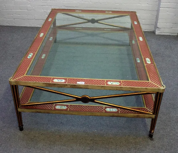 A large lacquered brass, glass and polychrome painted rectangular two tier coffee table, on tapering fluted supports, 155cm wide x 50cm high.