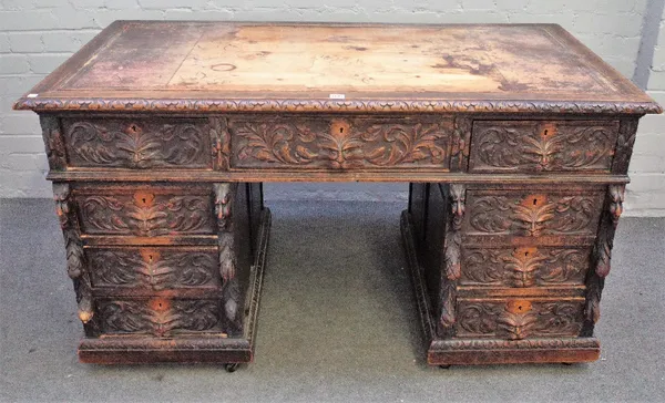 A Victorian carved oak pedestal desk with nine drawers about the knee on a plinth base, 141cm wide x 79cm deep.