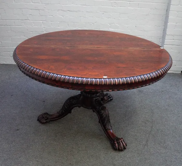 A late Regency rosewood centre table, the circular tilt-top with a gadrooned edge and bead and reel moulding, on  lotus carved and turned pillar, the