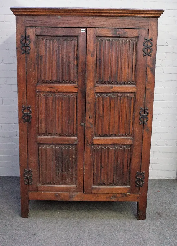 A 17th century style oak hanging cupboard, of panelled construction, incorporating earlier elements, the moulded cornice above a pair of full length l