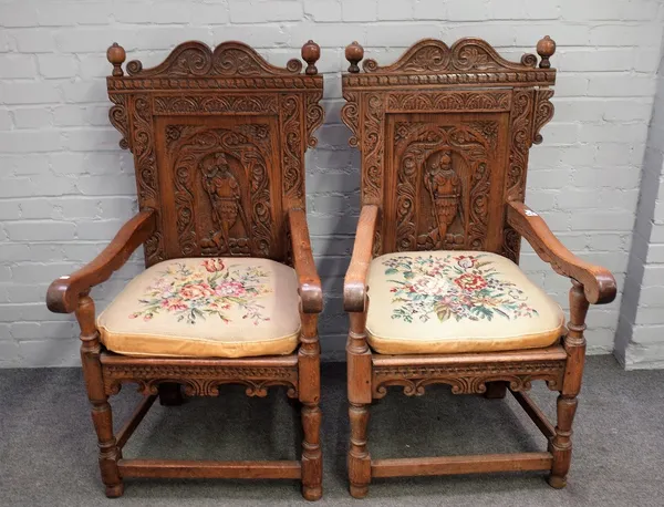 A pair of 17th century style carved oak Wainscot open armchairs on turned supports, 67cm wide x 119cm high (2).