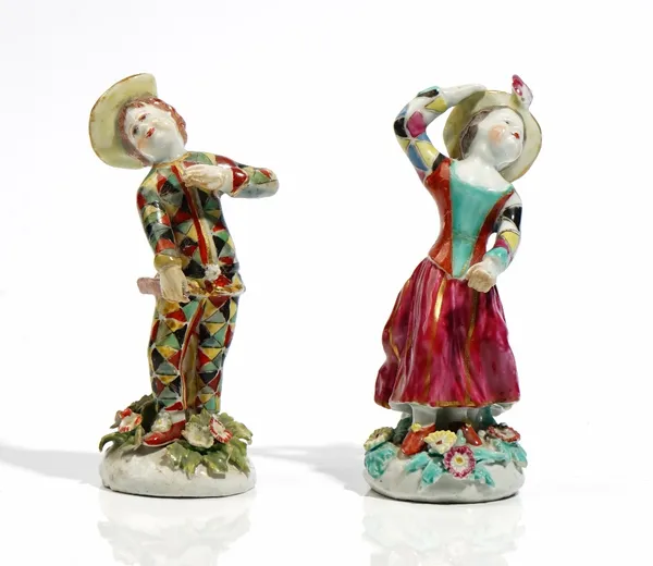 A matched pair of Bow figures of children dressed as Harlequin and Columbine, circa 1760, each standing in a dramatic pose on a mound base applied wit