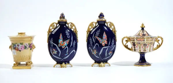 A pair of English porcelain blue-ground two-handled vases and two covers, late 19th century, of flattened ovoid form, each thickly enamelled with butt